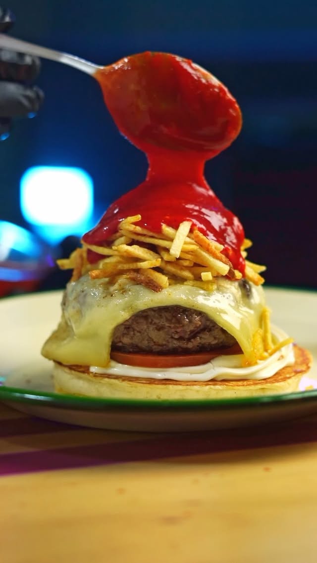 Hamburguesa de Ohana con salsa cayendo, foto nocturna